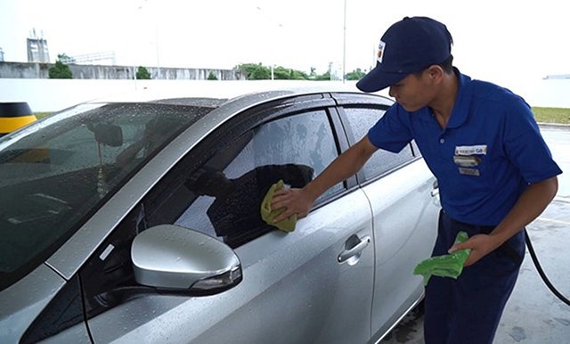 Việc nhân viên lau xe sau khi bơm xăng tại trạm xăng của Công ty Idemitsui Q8 (IQ8) mang lại sự hài lòng cho khách hàng. Ảnh: HOÀNG HIỆP