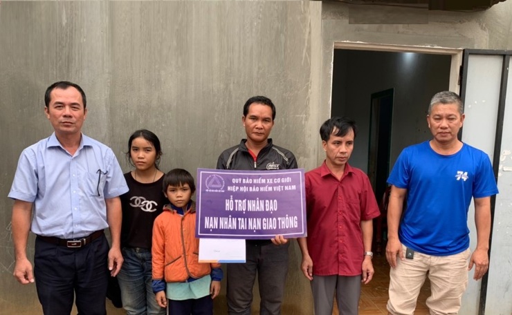 Đại diện Công ty Bảo Việt Kontum thay mặt Quỹ Bảo hiểm xe cơ giới trao hỗ trợ nhân đạo cho gia đình anh ABeo và chị A Phiên.