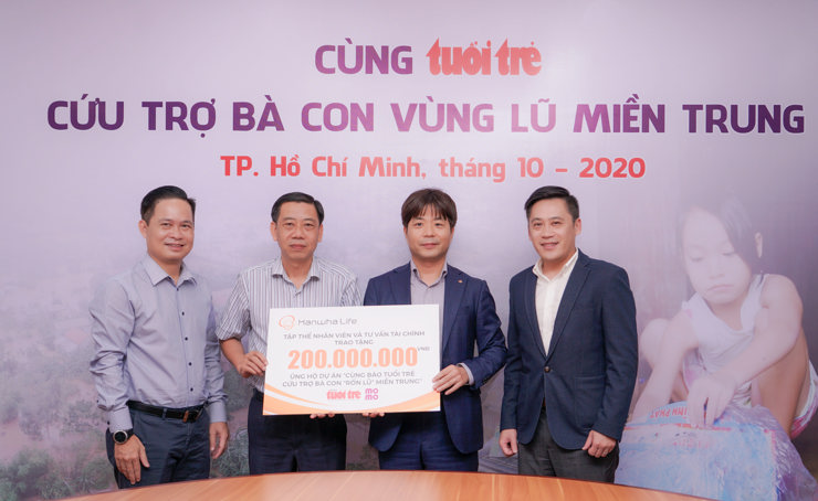 Ông Park Sung Mo - Phó Tổng Giám đốc Tài chính Hanwha Life Việt Nam (giữa, bìa phải) trao khoản tiền 200 triệu đồng ủng hộ chương trình “Cùng báo Tuổi trẻ cứu trợ bà con vùng lũ miền Trung” cho ông Nguyễn Văn Dũng - Phó Chánh Văn phòng Báo Tuổi trẻ (giữa, bìa trái).