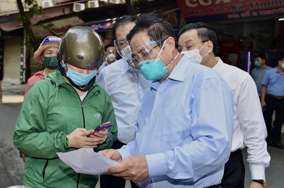 Thủ tướng Phạm Minh Ch&iacute;nh kiểm tra giấy đi đường của người d&acirc;n.