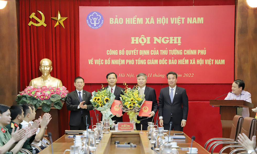 Bộ trưởng Bộ Tài chính Hồ Đức Phớc trao Quyết định bổ nhiệm, tặng hoa chúc mừng hai tân Phó Tổng giám đốc BHXH Việt Nam Chu Mạnh Sinh và Nguyễn Đức Hoà.